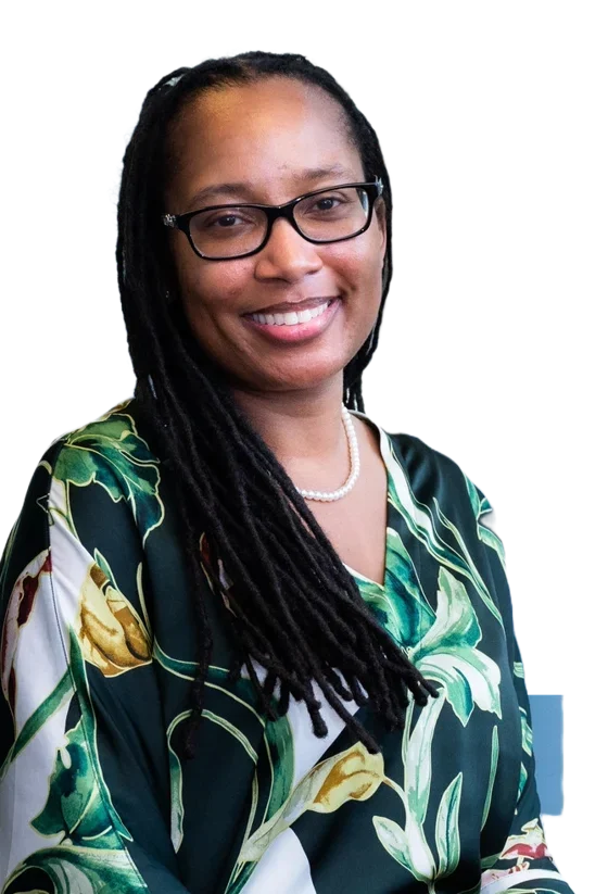 Portrait of Dr. Brandeis Marshall, smiling, with glasses and long locs, wearing a green floral top.